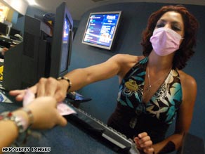 A movie theater attendent in Guadalajara, Mexico takes precautions at work.