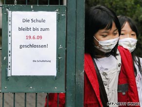 Children walk through the front gate of a Japanese school in Germany which has been closed following a swine flu outbreak.