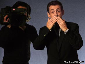 The future of French kissing? French President Nicolas Sarkozy keeps his distance with a kiss and a wave