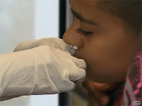 Brandon Marti, 13, receives a dose of the intranasal vaccine for the novel H1N1 flu Tuesday.