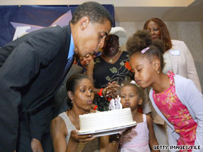 Future president Barack Obama and his family blow out the candles on his birthday cake in 2004.