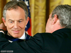 Tony Blair shakes hand with Colombian President Alvaro Uribe while former Australian PM John Howard watches.