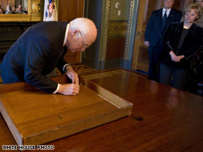Vice President Cheney signs his office desk, following a tradition started by Teddy Roosevelt.