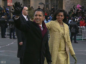 Barack and Michelle Obama wave to throngs of supporters en route to the White House on Tuesday.