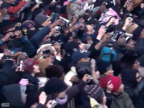 Crowds at the inaugural parade cheer and snap photos of President Obama on Tuesday.