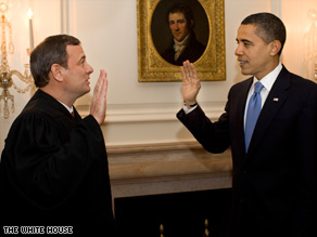 Barack Obama is pictured at the inauguration on Tuesday in Washington as Michelle Obama watches.