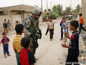 A U.S. soldier plays soccer with children in mid-June in the northern Iraqi city of Mosul.