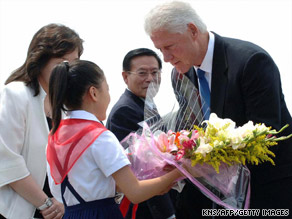 Former President Clinton receives flowers from a girl Tuesday upon landing in Pyongyang, North Korea.