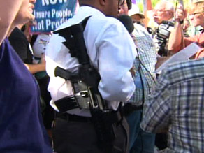 A man is shown legally carrying a rifle at a protest against President Obama on Monday in Phoenix, Arizona.