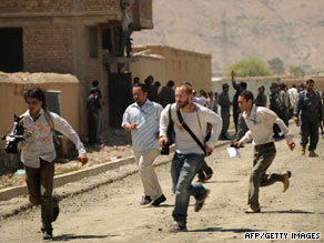 Journalists run at the site of a gunfight between gunmen and Afghan police in Kabul on August 20.