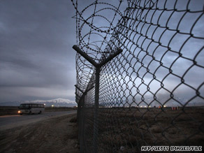 A bus passes a fence topped with razor wire at Bagram Air Base, Afghanistan, earlier this year.