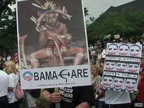 A Tea Party rally protester holds a sign with President Obama depicted as a witch doctor.