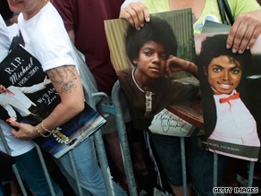 Images of Michael Jackson like these held by fans at the Apollo Theater may prove profitable to his estate.