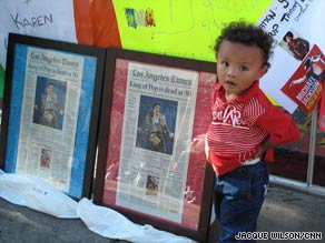 YaYa, 2, stands near framed coverage of Michael Jackson's death on the Walk of Fame on Sunday.