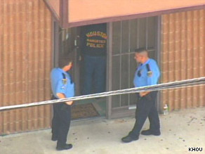 Officers stand outside the Houston, Texas, medical office of Dr. Conrad Murray.