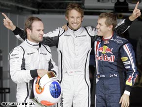 Bright as a Button: Jenson, center, celebrates pole in Spain flanked by Barrichello, left, and Red Bull's Vettel.