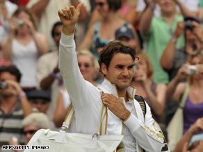 Federer gives a thumbs-up after reaching the last eight at Wimbledon where he is chasing a grand slam record win.