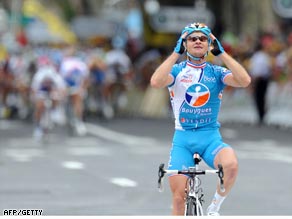 Vockler raises his arms in triumph with the bunch coming up fast behind.