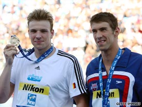 Michael Phelps looks on as Paul Bierdermann (left) shows off his world 200m freestyle gold medal.
