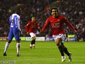 Carlos Tevez celebrates his equalizing goal as Manchester United edged closer to retaining their title.