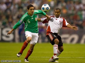 Mexico's match-winner Oscar Rojas tussles with Trinidad and Tobago's goalscorer Hayden Tinto.