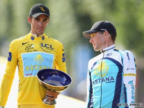 Lance Armstrong (right) looks on after Alberto Contador is handed the Tour de France trophy in Paris.