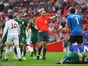 Referee Eriksson points to the spot as Slovenian players protest.