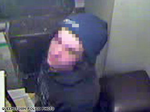 Having removed his balaclava after his efforts made him hot, the would-be burglar looks up at a security camera.