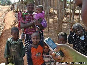 A Kenya Ministry of Health worker collects health data from a woman and her son.