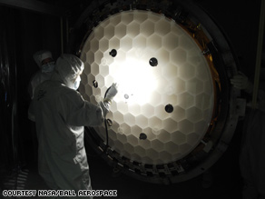 Scientists inspect the Kepler telescope's primary mirror honeycomb structure.
