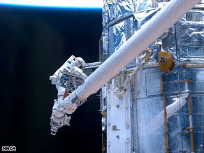 An astronaut works on the Hubble Space Telescope during a spacewalk Monday.