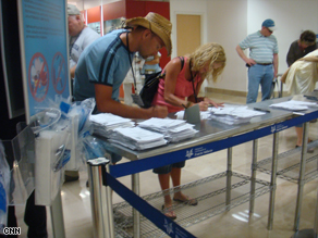 Travelers leaving a Mexican airport fill out questionnaires about their health.