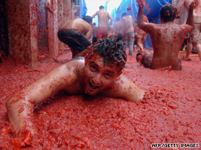 A participant at the annual Tomatina festival in Spain dives for cover amidst an intense volley of over-ripe tomatoes