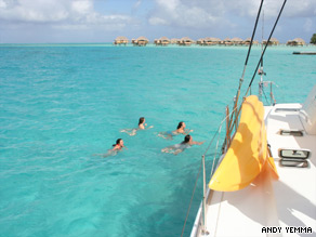 Four friends swim in a lagoon in Tahiti.