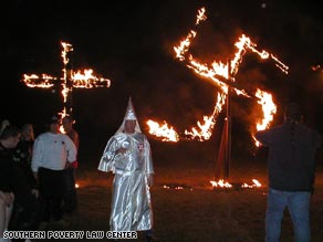 A cross and swastika are burned at an event called 