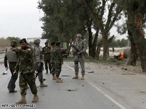 Afghan and U.S. soldiers walk at the site of a suicide attack outside Jalalabad in Nangarhar province Sunday.