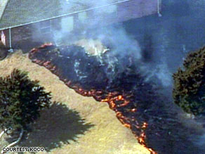 Wildfire threatens a house in Edmond, Oklahoma, on Friday.