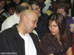 Victor Guavares discusses his plans with his wife, Yajaira, to bid on a foreclosure at an auction Sunday in New York.