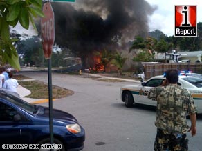 Bystanders watch the flames after the plane crash Friday in Fort Lauderdale, Florida.