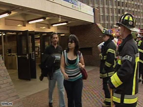 Passengers walk past firefighters at a Green Line station in Boston after trolley collision Friday evening.