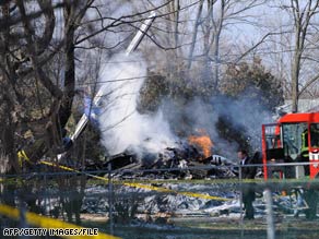 An investigator walks past the wreckage from a plane crash in Clarence Center, New York, in February.