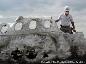 Personal effects are removed from the site of an airline disaster.