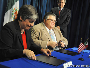 U.S. Homeland Security Secretary Janet Napolitano and Mexican offical Agustin Carstens sign a pact Monday.