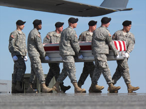 A flag-draped coffin is carried off a plane Tuesday at Dover Air Force Base in Delaware.
