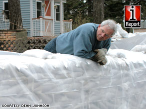 A Fargo resident surveys the sandbags outside his home, located about 15 feet from the Red River, on Tuesday.