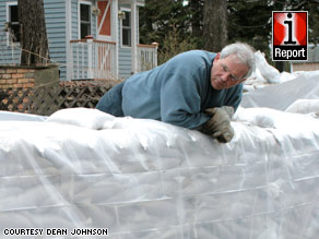 A Fargo resident surveys sandbags Tuesday outside his home, located about 15 feet from the Red River.