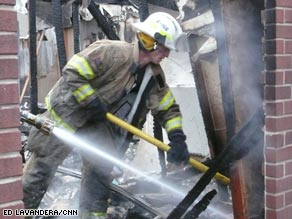 A firefighter sifts through the rubble of a burned home Friday in Midwest City, Oklahoma.