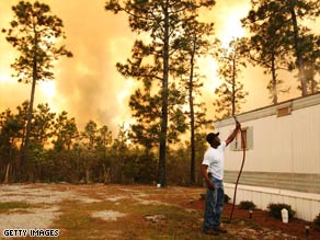 Scott Vereen sprays water on his family's home Thursday near Conway, South Carolina.