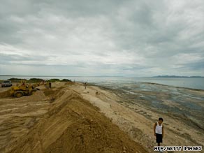 Heavy equipment moves beach sand to form a barrier on Tuesday in Puerto San Carlos, Mexico, on the Baja Peninsula.