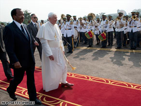 Cameroonian President Paul Biya, left, walks with Pope Benedict XVI at the airport in Yaounde, Tuesday.